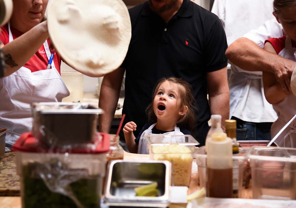 Sienna Saliani, three, watches a dough mid toss at the Pizza and Magic event at Without Papers Pizza (WOP) in Calgary on Sunday, Sept. 10, 2017. Pizza and Magic is only one of the sorts of events WOP holds at their restaurant in Inglewood. (Photo by Sam Hefford/The Press)